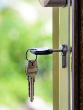 pexels-photo-101808-101808 Key inserted in door lock against a blurred green background, symbolizing security and real estate.