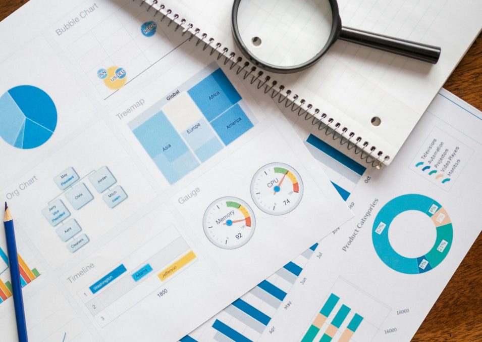 A set of financial charts and graphs with a magnifying glass, perfect for business reports.